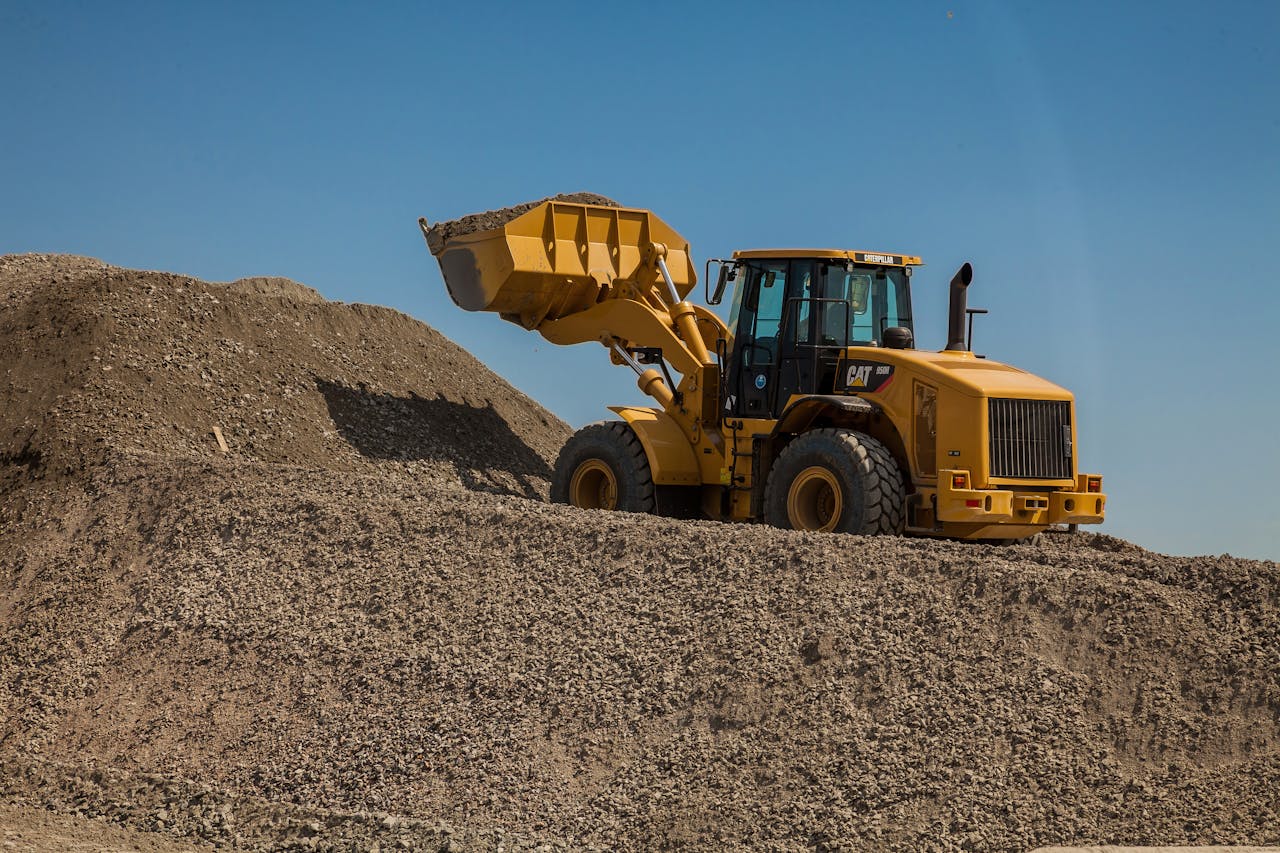Heavy construction equipment: A powerful front loader in a quarry loads a bucket with crushed stone.